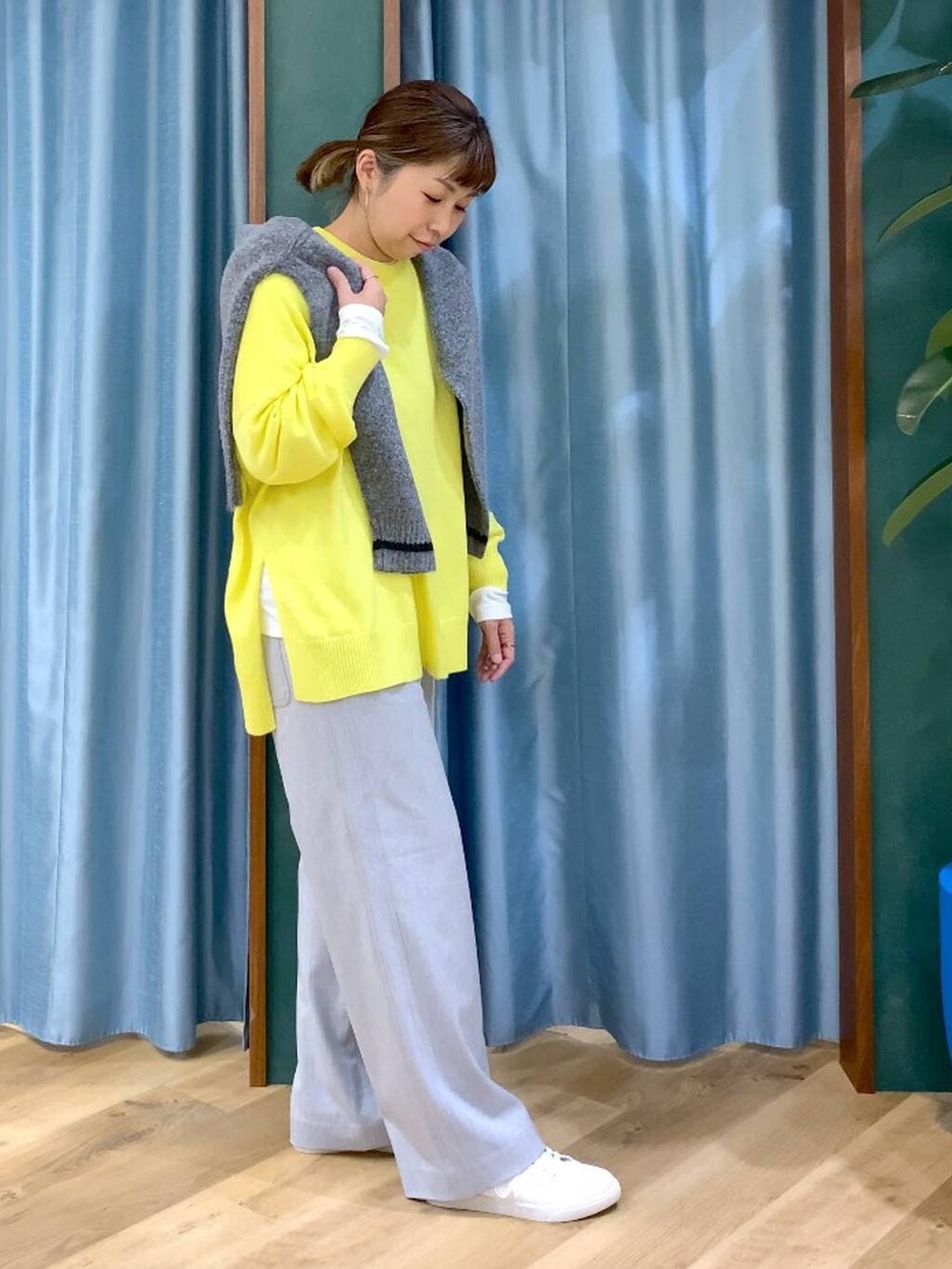 グレー系のカーディガン/ボレロ、ホワイト系のTシャツ/カットソー、イエロー系のニット/セーターを着用したレディースの秋コーディネートの4枚目の写真