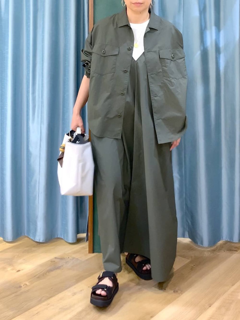 ホワイト系のトートバッグ、グリーン系のシャツ/ブラウス、ホワイト系のTシャツ/カットソーを着用したレディースの春コーディネートの7枚目の写真