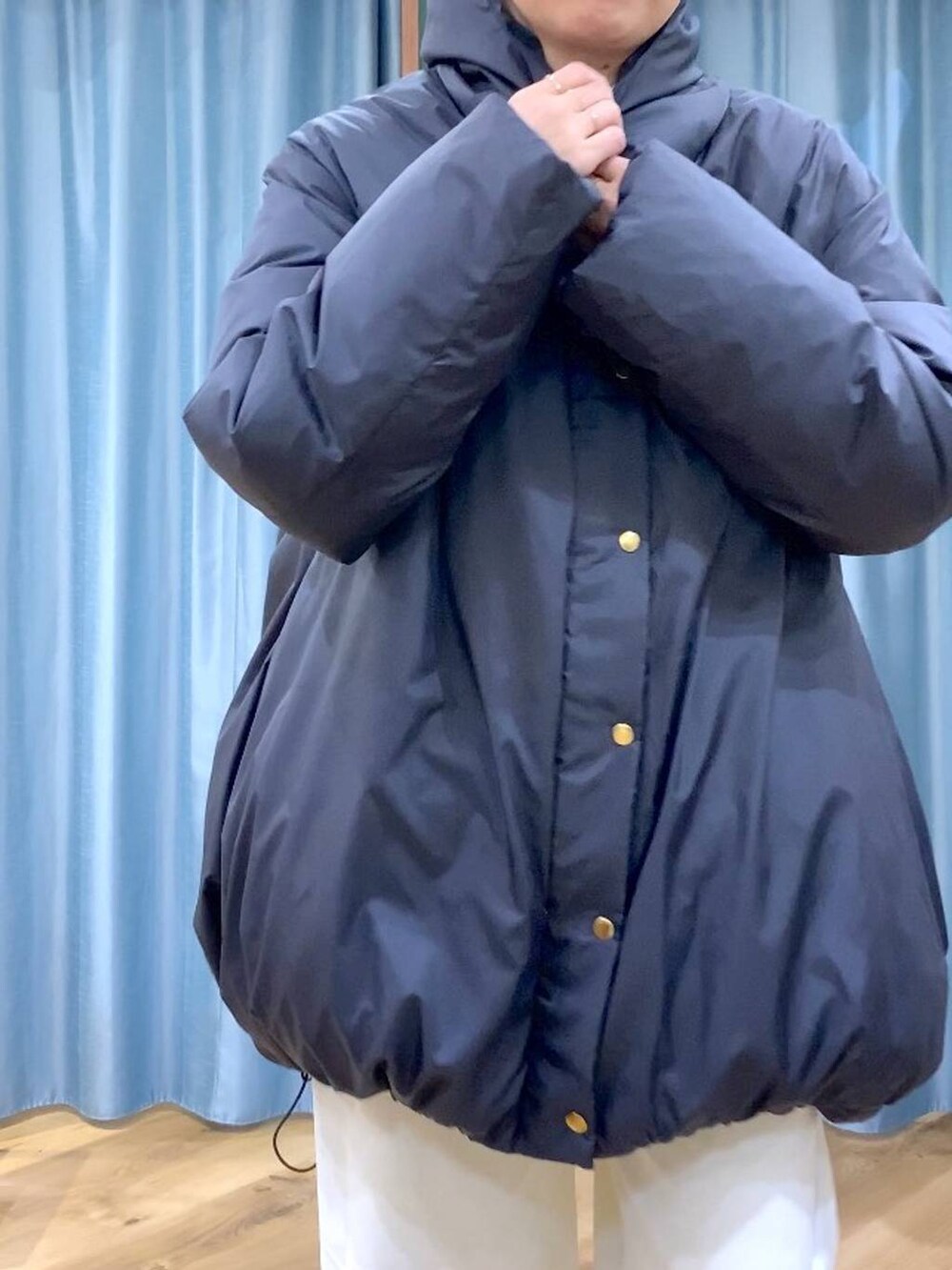 ブルー系のシャツ/ブラウス、ブラック系のダウンジャケット/コート、ブラウン系のローファーを着用したレディースの秋コーディネートの8枚目の写真