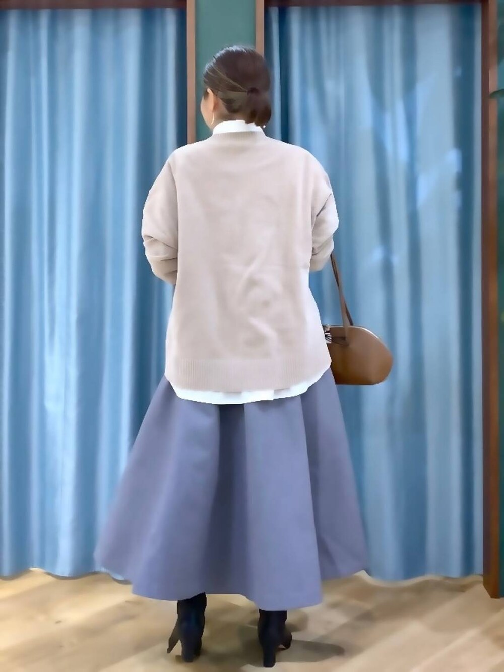 イエロー系のトートバッグ、ホワイト系のシャツ/ブラウス、ベージュ系のニット/セーターを着用したレディースの秋コーディネートの3枚目の写真