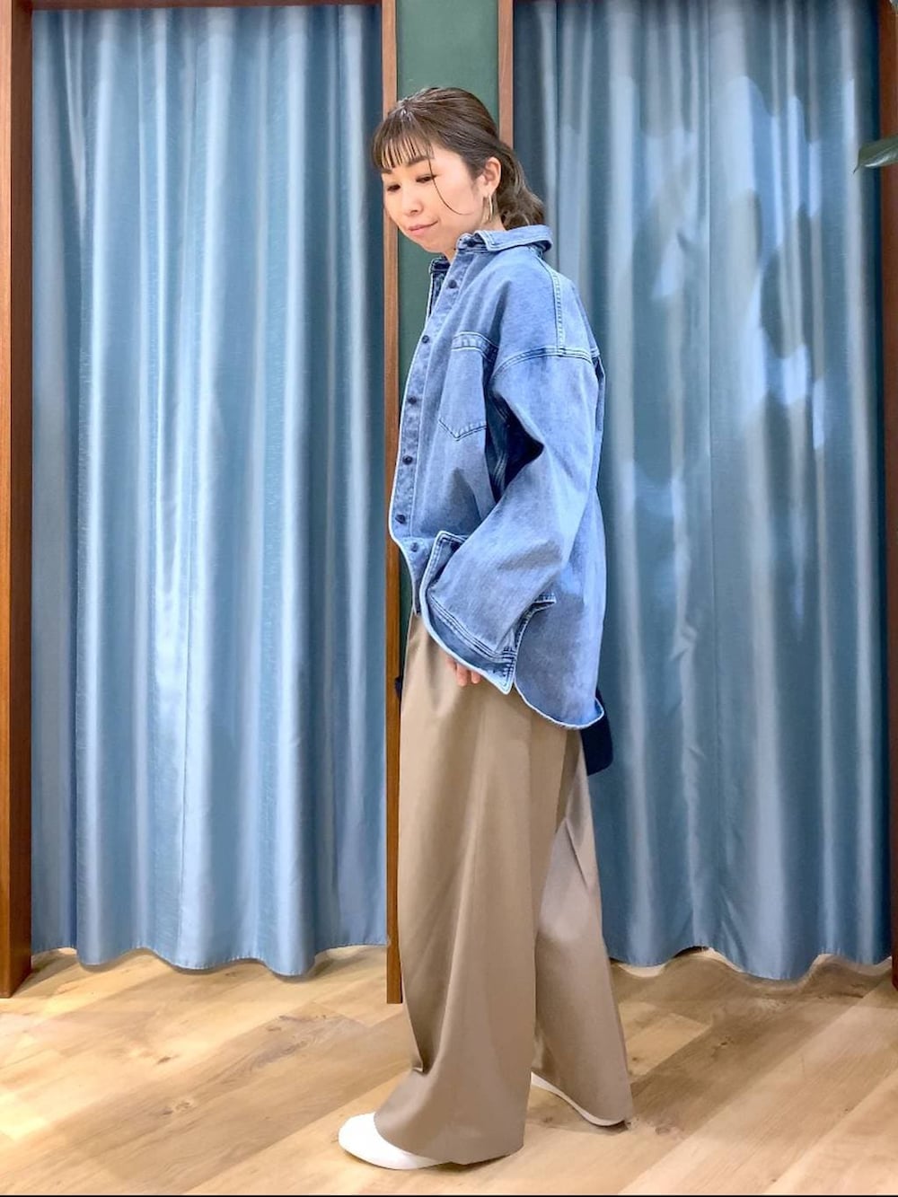 ブルー系のシャツ/ブラウス、ブルー系のトートバッグ、ブラウン系のスニーカーを着用したレディースの冬コーディネートの2枚目の写真