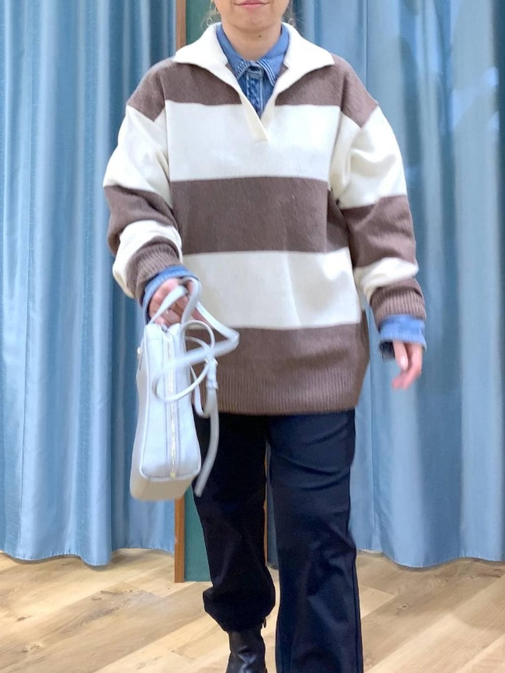 ブラック系のブーツ、ホワイト系のニット/セーター、ブルー系のシャツ/ブラウスを着用したレディースの冬コーディネートの9枚目の写真