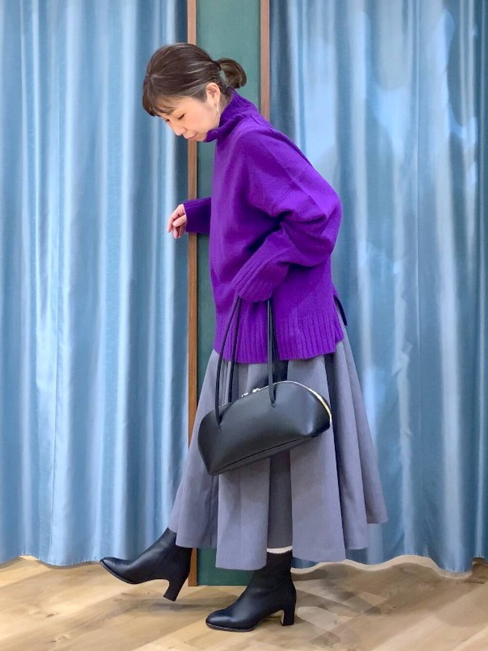 ブラック系のトートバッグ、グレー系のスカート、ブラック系のブーツを着用したレディースの秋コーディネートの3枚目の写真