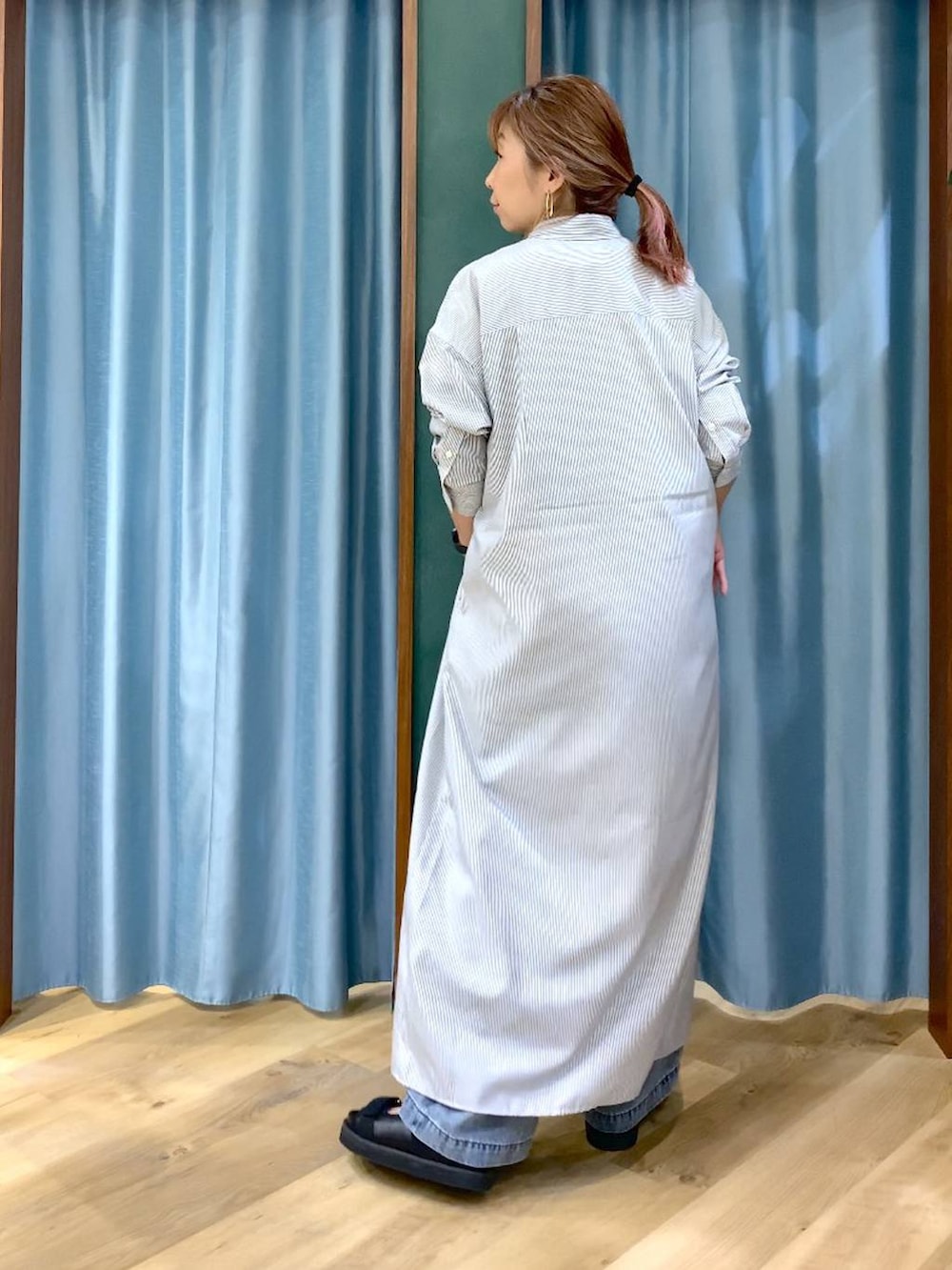 ブラック系のワンピース、ブルー系のデニムパンツ、ブラック系のサンダルを着用したレディースの春コーディネートの5枚目の写真