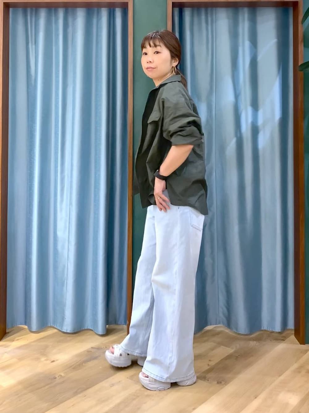 ブルー系のデニムパンツ、ホワイト系のTシャツ/カットソー、グレー系のサンダルを着用したレディースの春コーディネートの5枚目の写真