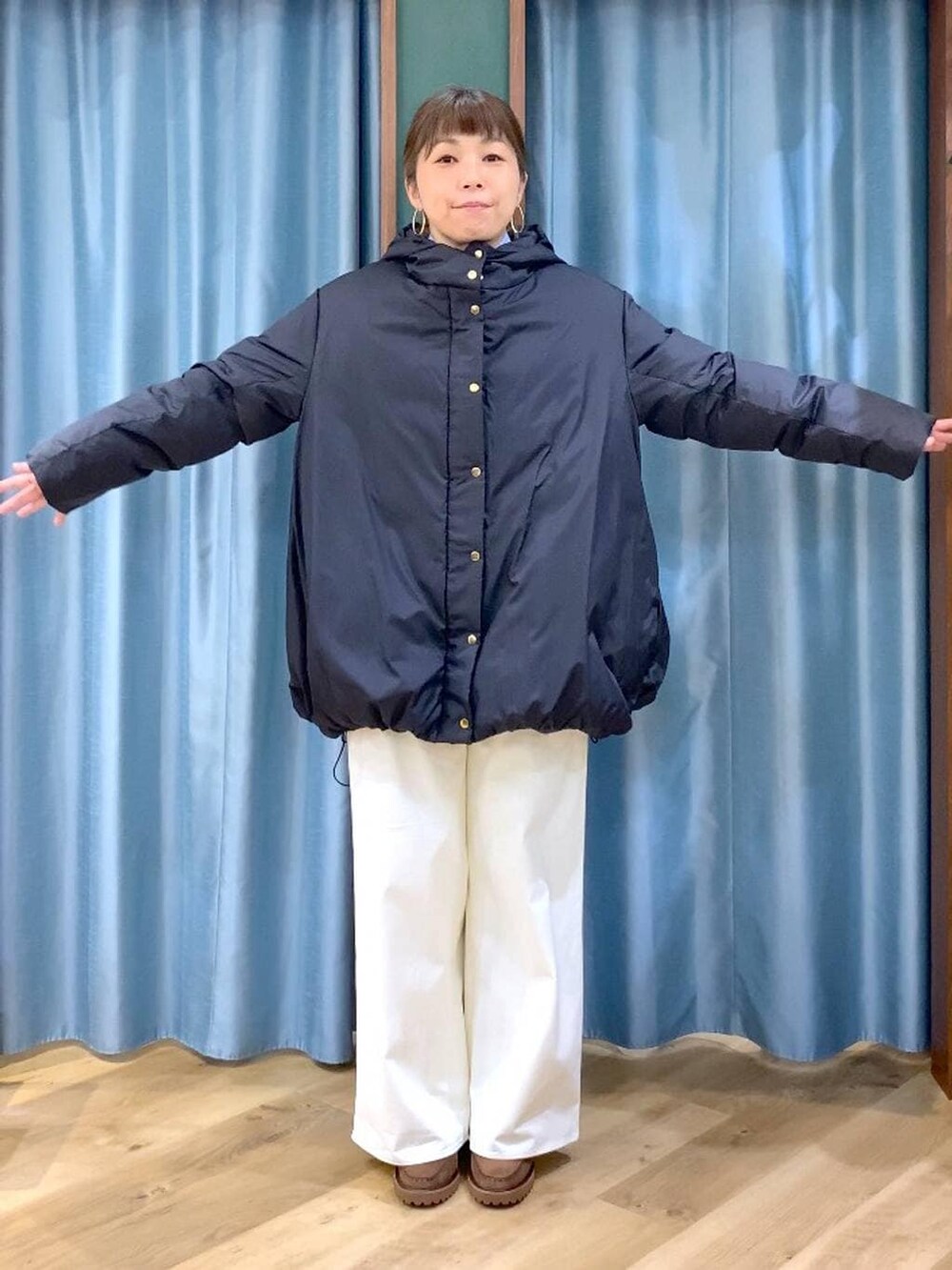 ブルー系のシャツ/ブラウス、ブラック系のダウンジャケット/コート、ブラウン系のローファーを着用したレディースの秋コーディネートの3枚目の写真