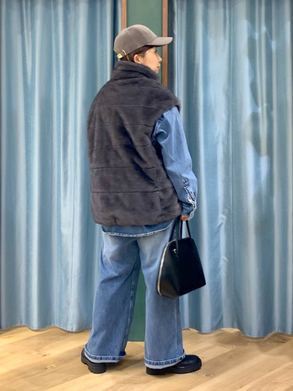 ブラック系のブーツ、ブルー系のシャツ/ブラウス、ブルー系のデニムパンツを着用したレディースの秋コーディネートの2枚目の写真