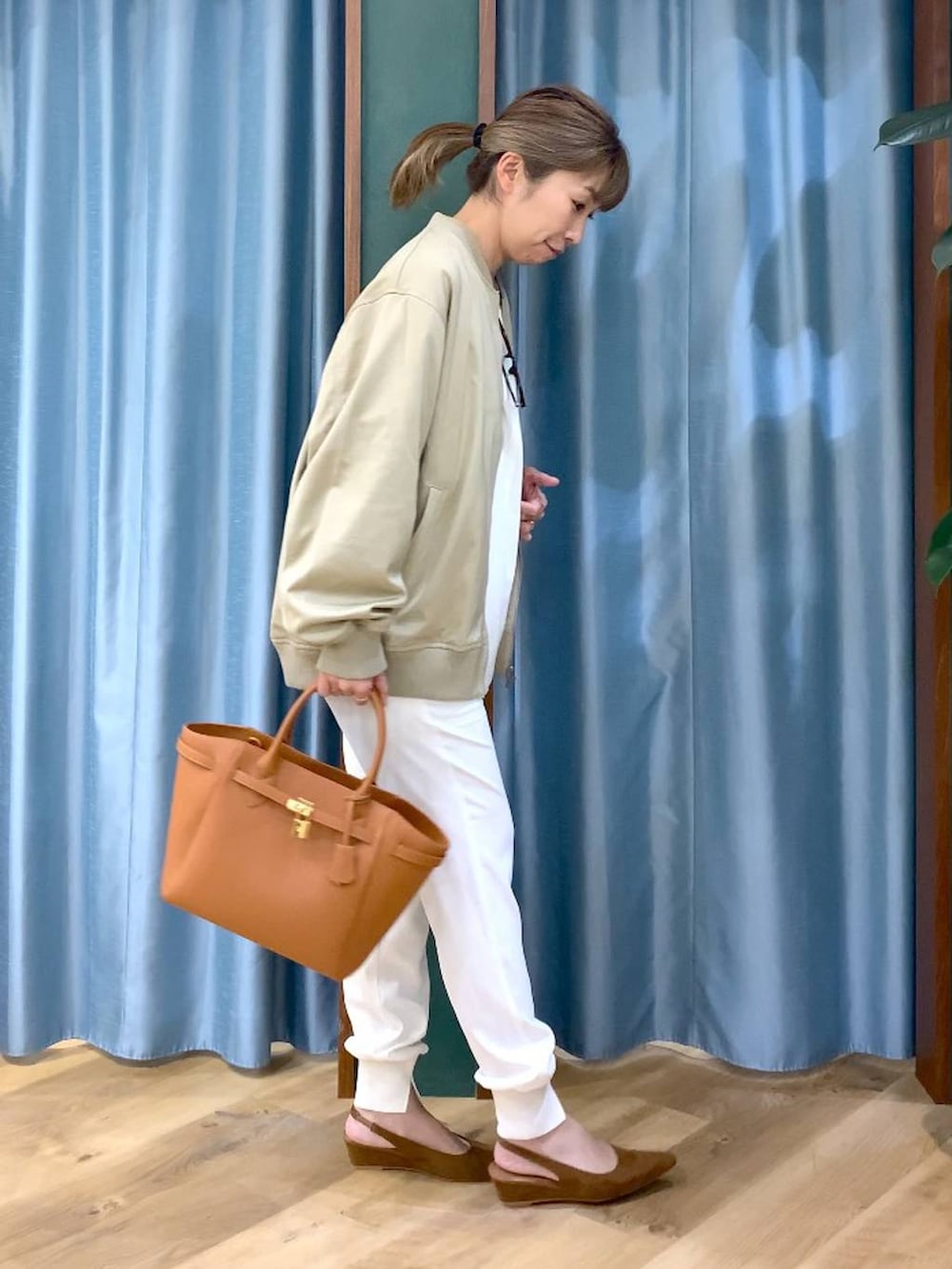 ベージュ系のMA-1、ホワイト系のTシャツ/カットソー、イエロー系のハンドバッグを着用したレディースの冬コーディネートの4枚目の写真