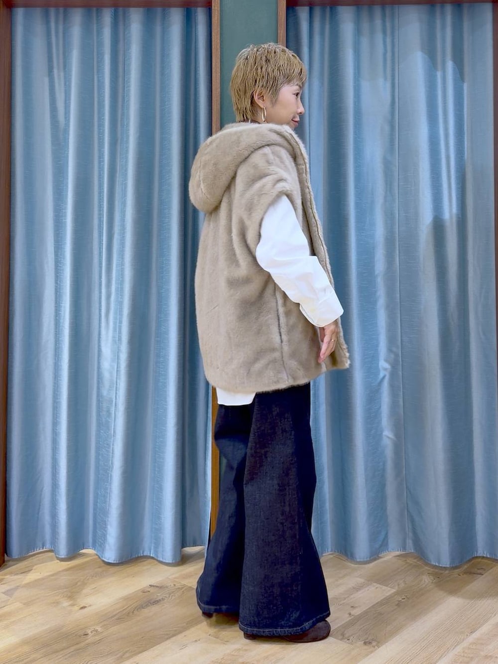 ブラウン系のブーツ、ブルー系のデニムパンツ、ホワイト系のシャツ/ブラウスを着用したレディースの秋コーディネートの6枚目の写真