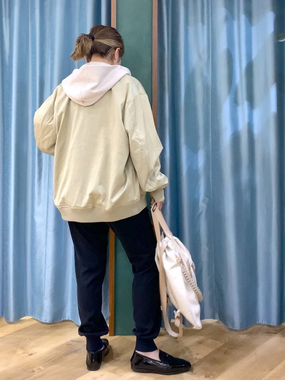 ベージュ系のパーカー、グリーン系のMA-1、ホワイト系のTシャツ/カットソーを着用したレディースの冬コーディネートの5枚目の写真