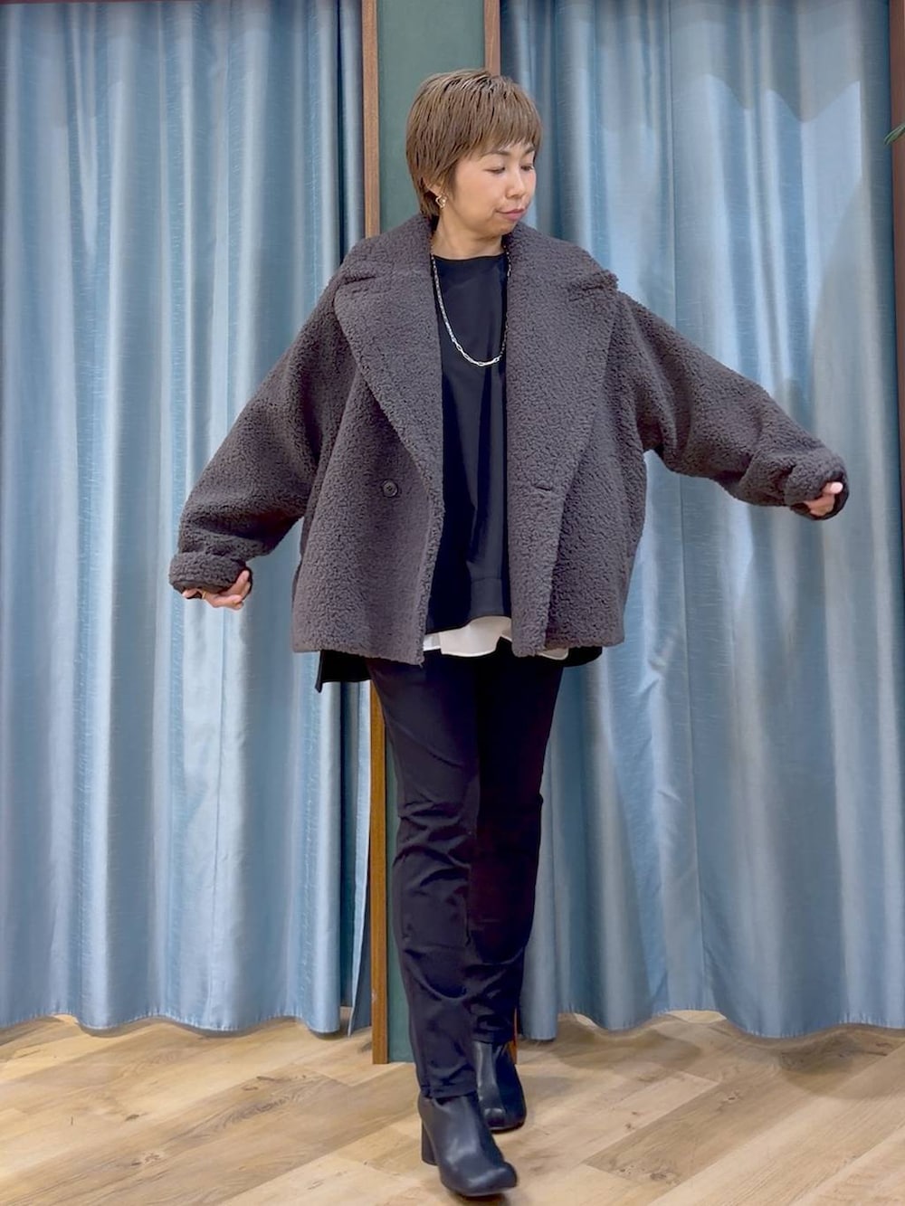 ブラック系のその他パンツ、ブラック系のブーツ、ホワイト系のTシャツ/カットソーを着用したレディースの秋コーディネートの5枚目の写真