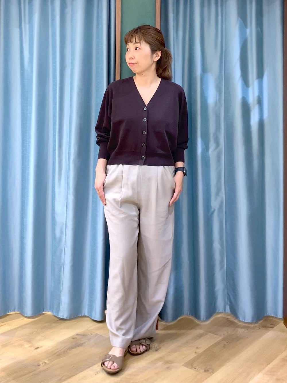 ブラウン系のカーディガン/ボレロ、ベージュ系のその他パンツ、ブラウン系のサンダルを着用したレディースの春コーディネートの2枚目の写真