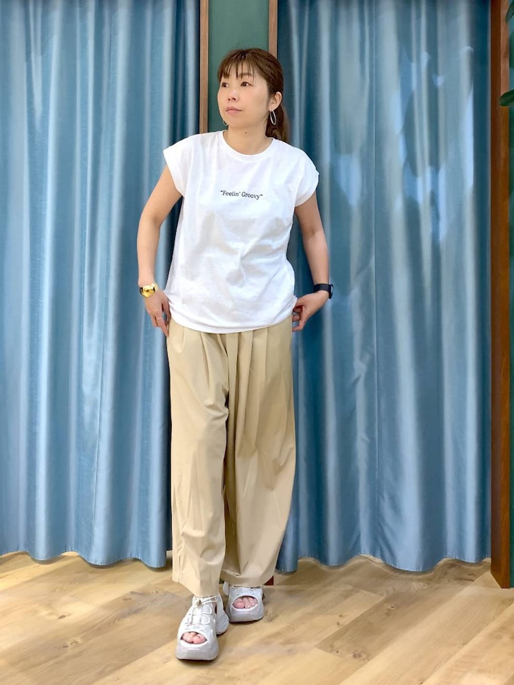 ベージュ系のその他パンツ、ホワイト系のTシャツ/カットソー、グレー系のサンダルを着用したレディースの春コーディネートの5枚目の写真