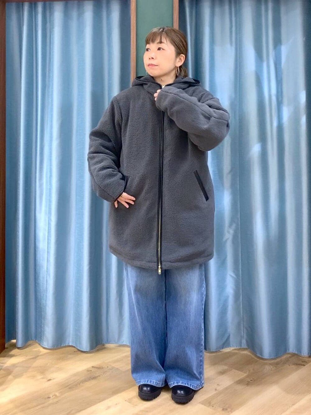 ブラック系のブーツ、ブルー系のデニムパンツ、ブルー系のニット/セーターを着用したレディースの冬コーディネートの8枚目の写真