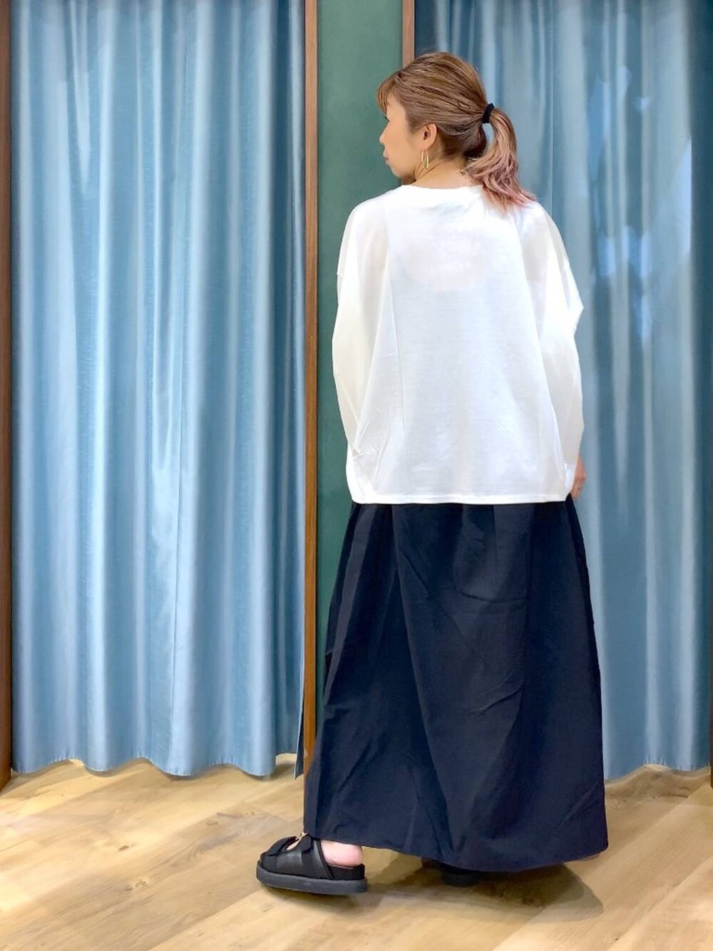 ホワイト系のTシャツ/カットソー、ブラック系のスカート、ブラック系のサンダルを着用したレディースの春コーディネートの5枚目の写真