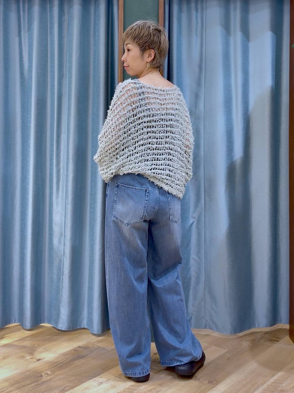 グレー系のタンクトップ、ブルー系のデニムパンツ、ブラック系のサンダルを着用したレディースの夏コーディネートの4枚目の写真