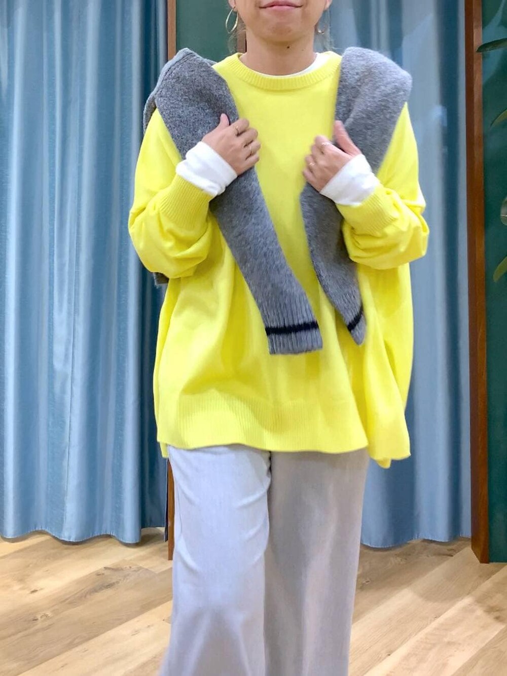 グレー系のカーディガン/ボレロ、ホワイト系のTシャツ/カットソー、イエロー系のニット/セーターを着用したレディースの秋コーディネートの6枚目の写真