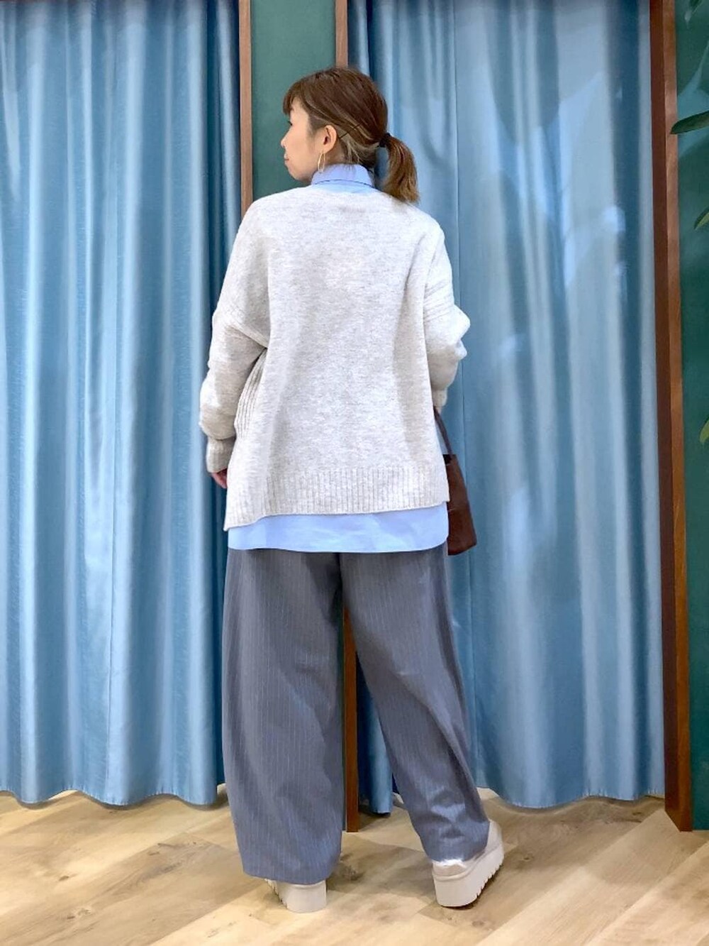 ブルー系のシャツ/ブラウス、ベージュ系のスリッポン、ベージュ系のニット/セーターを着用したレディースの冬コーディネートの5枚目の写真