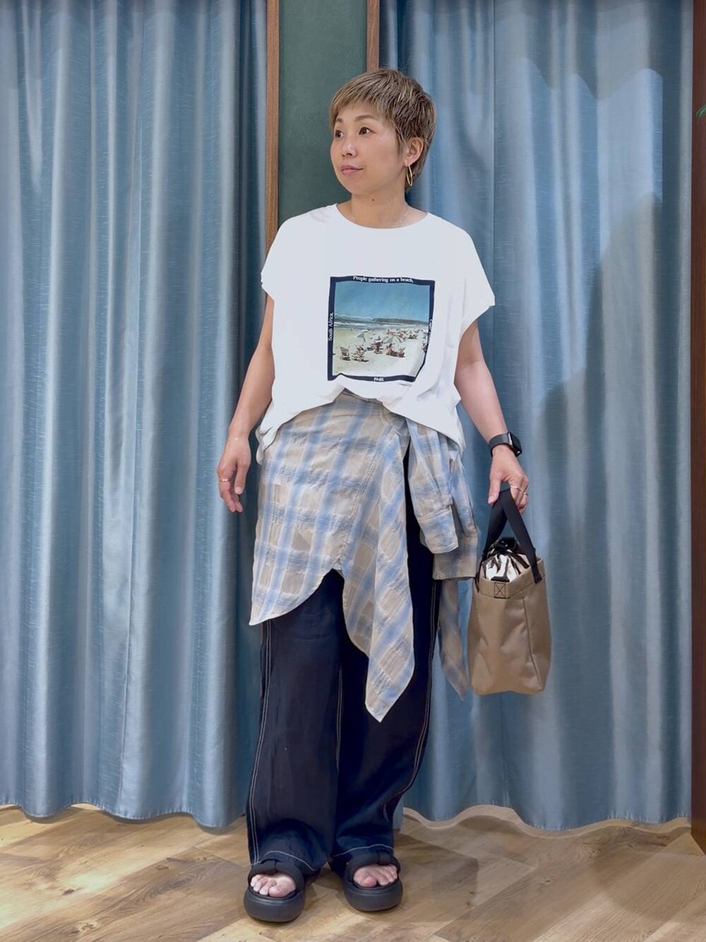 ホワイト系のTシャツ/カットソー、ブルー系のその他パンツ、ベージュ系のショルダーバッグを着用したレディースの夏コーディネートの2枚目の写真