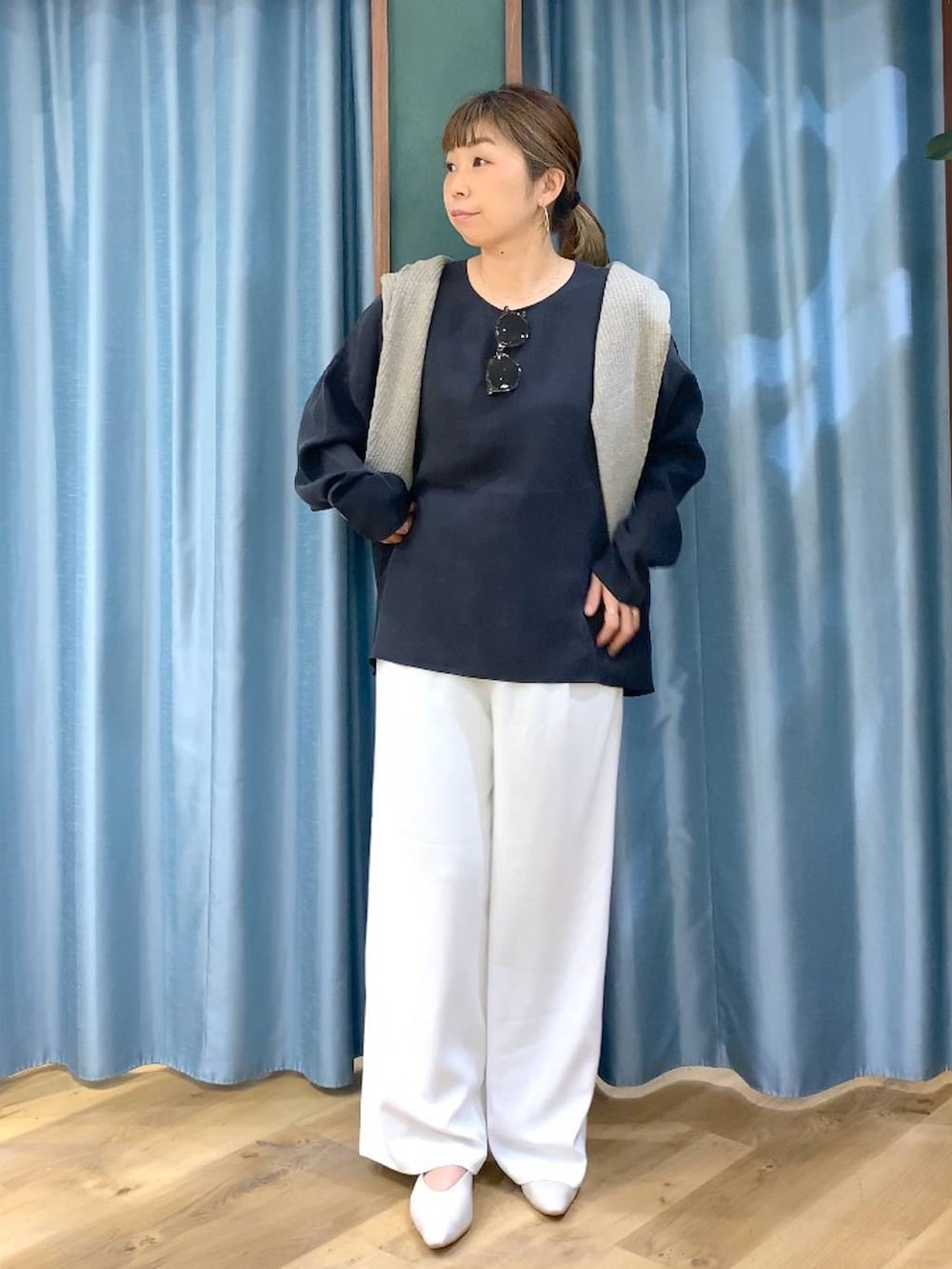 ホワイト系のスラックス、ベージュ系のカーディガン/ボレロ、ホワイト系のパンプスを着用したレディースの冬コーディネートの5枚目の写真