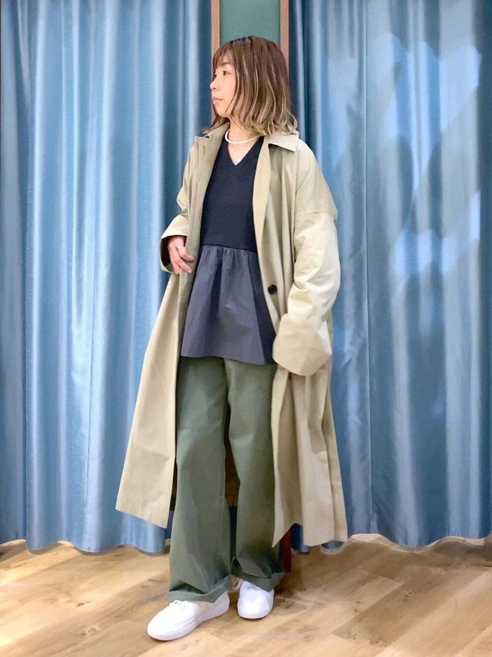 グリーン系のその他パンツ、ベージュ系のステンカラーコート、グレー系のTシャツ/カットソーを着用したレディースの冬コーディネートの2枚目の写真