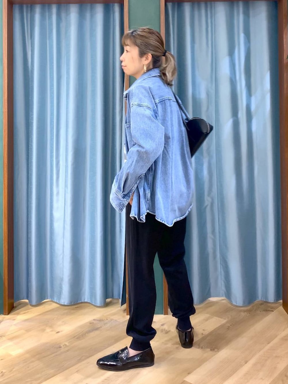 ブルー系のシャツ/ブラウス、ホワイト系のTシャツ/カットソー、ブラック系のハンドバッグを着用したレディースの春コーディネートの6枚目の写真