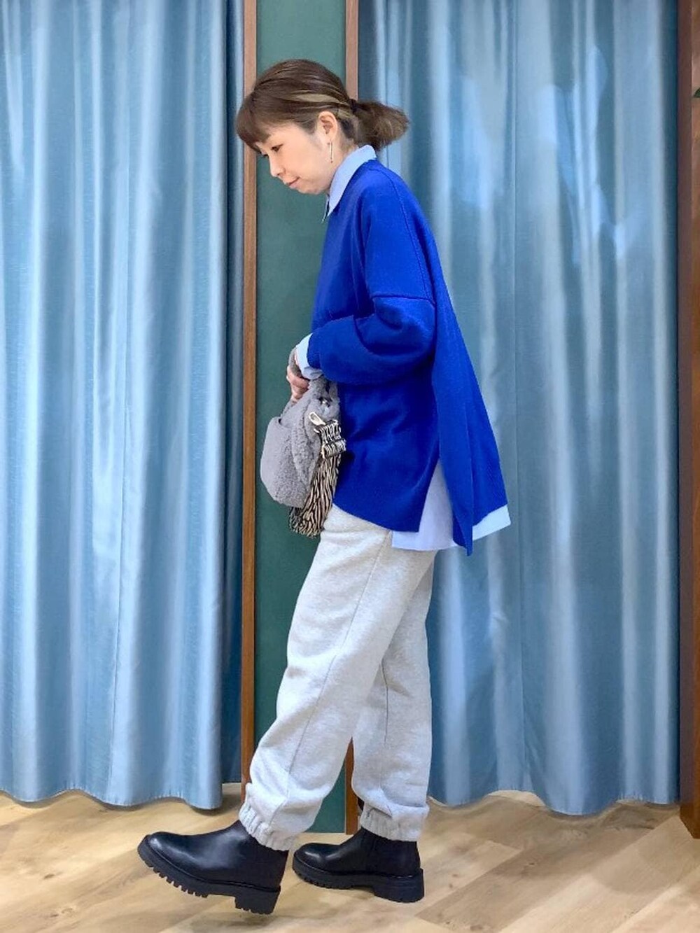 ブラック系のブーツ、ブルー系のシャツ/ブラウス、グレー系のトートバッグを着用したレディースの秋コーディネートの2枚目の写真