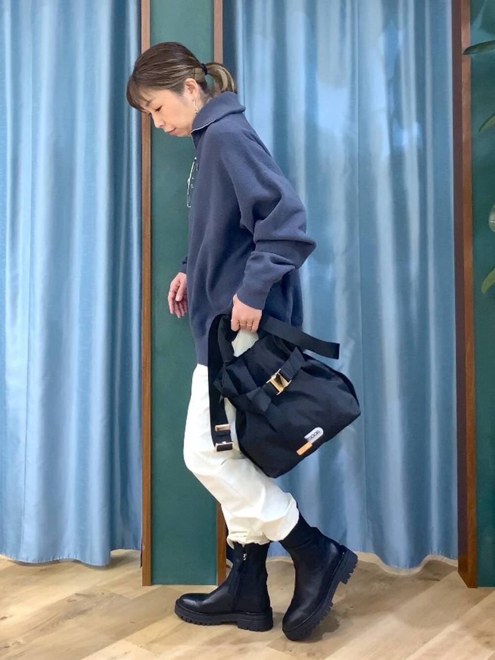 ブラック系のブーツ、ブラック系のショルダーバッグ、ホワイト系のその他パンツを着用したレディースの秋コーディネートの2枚目の写真