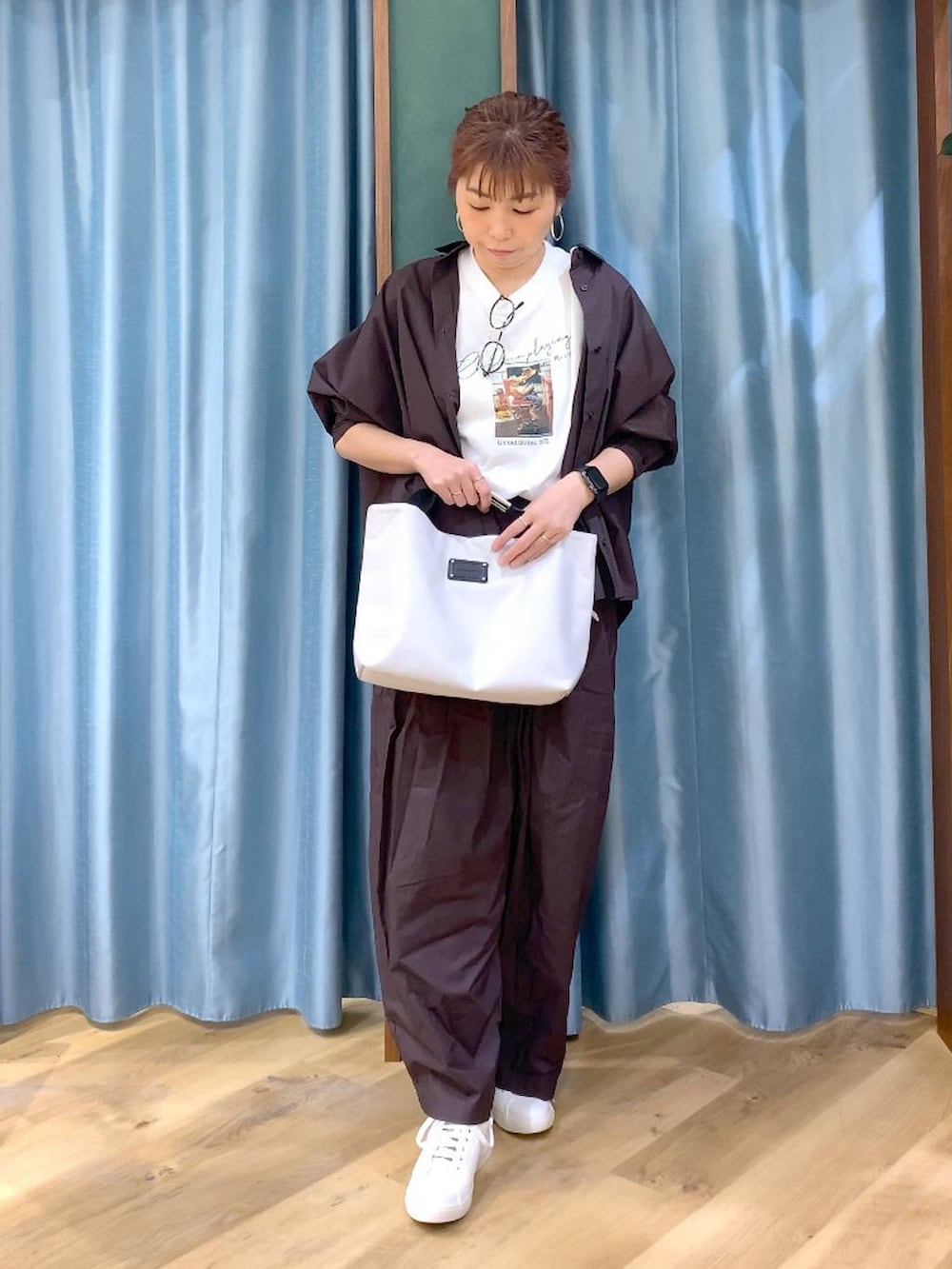 ブラウン系のその他パンツ、ブラウン系のスニーカー、ホワイト系のトートバッグを着用したレディースの春コーディネートの2枚目の写真