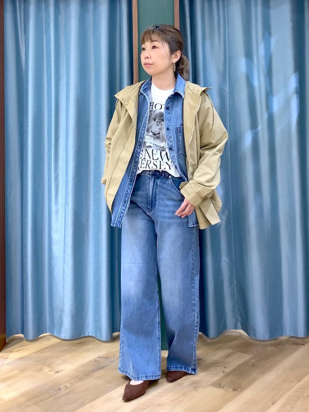 ブルー系のシャツ/ブラウス、ブラウン系のパンプス、ブルー系のデニムパンツを着用したレディースの春コーディネートの2枚目の写真