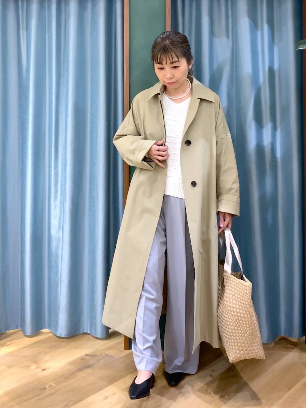 ホワイト系のニット/セーター、グレー系のその他パンツ、ベージュ系のステンカラーコートを着用したレディースの冬コーディネートの2枚目の写真