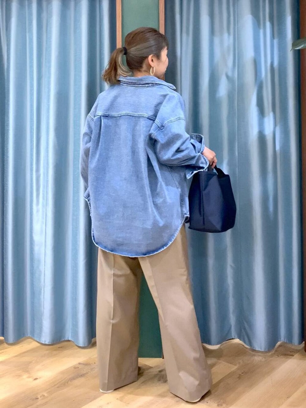 ブルー系のシャツ/ブラウス、ブルー系のトートバッグ、ブラウン系のスニーカーを着用したレディースの冬コーディネートの4枚目の写真