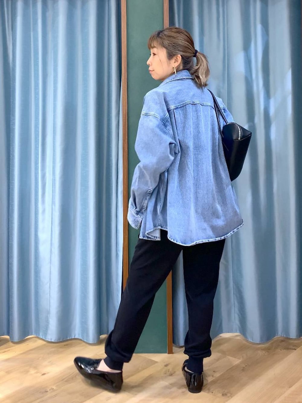 ブルー系のシャツ/ブラウス、ホワイト系のTシャツ/カットソー、ブラック系のハンドバッグを着用したレディースの春コーディネートの4枚目の写真