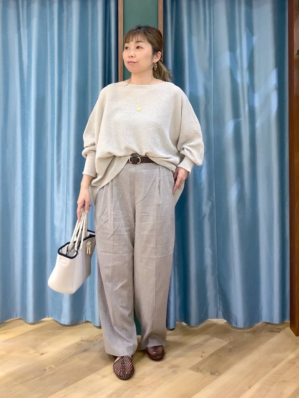 ベージュ系のニット/セーター、ホワイト系のトートバッグ、ベージュ系のその他パンツを着用したレディースの春コーディネートの2枚目の写真