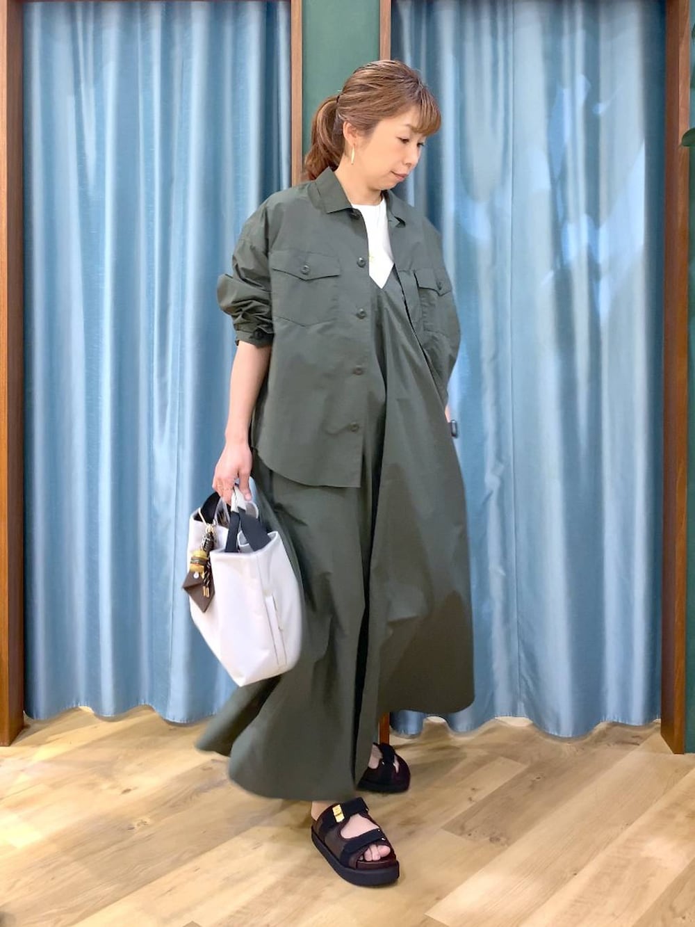 ホワイト系のトートバッグ、グリーン系のシャツ/ブラウス、ホワイト系のTシャツ/カットソーを着用したレディースの春コーディネートの4枚目の写真