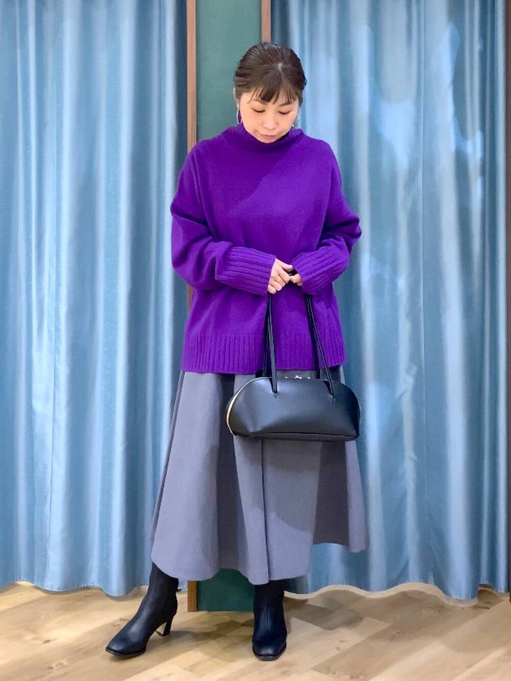 ブラック系のトートバッグ、グレー系のスカート、ブラック系のブーツを着用したレディースの秋コーディネートの4枚目の写真