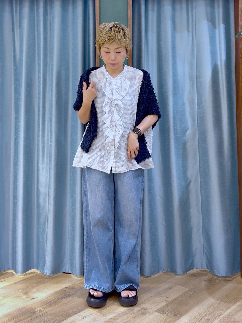 ブルー系のデニムパンツ、ブラック系のサンダル、ホワイト系のシャツ/ブラウスを着用したレディースの夏コーディネートの2枚目の写真