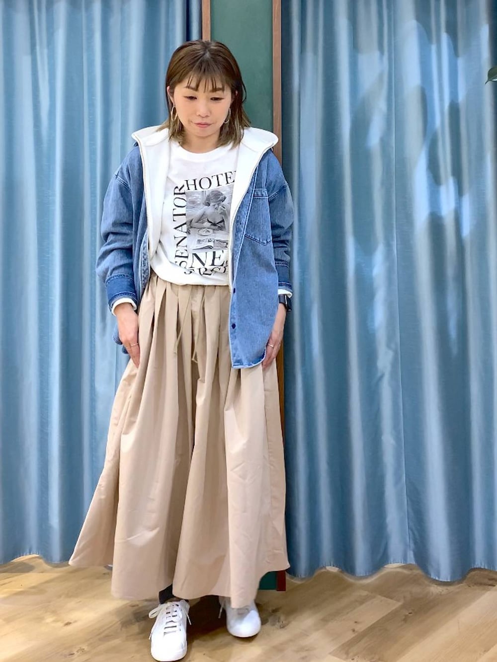 ブルー系のシャツ/ブラウス、ベージュ系のスカート、ホワイト系のTシャツ/カットソーを着用したレディースの冬コーディネートの2枚目の写真