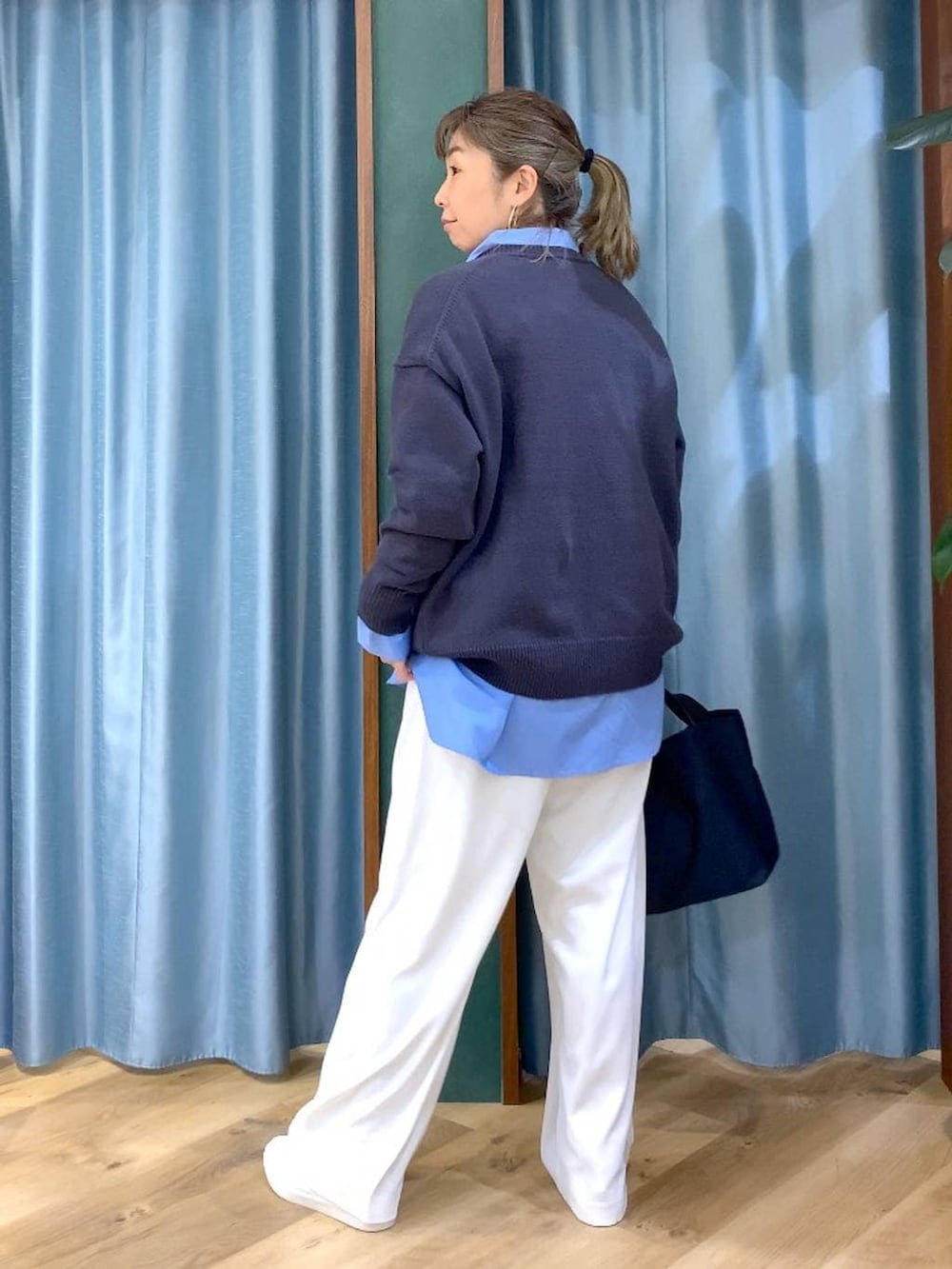 ホワイト系のスラックス、ブルー系のトートバッグ、グレー系のニット/セーターを着用したレディースの冬コーディネートの6枚目の写真