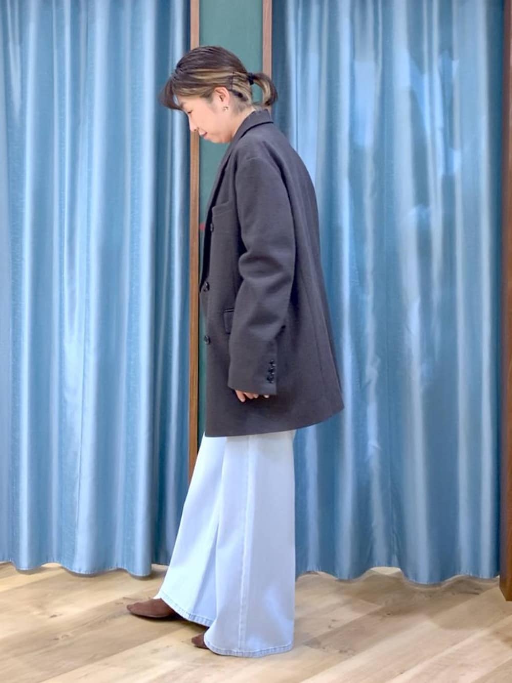 ブルー系のデニムパンツ、ブラウン系のテーラードジャケット、ブラウン系のパンプスを着用したレディースの秋コーディネートの5枚目の写真
