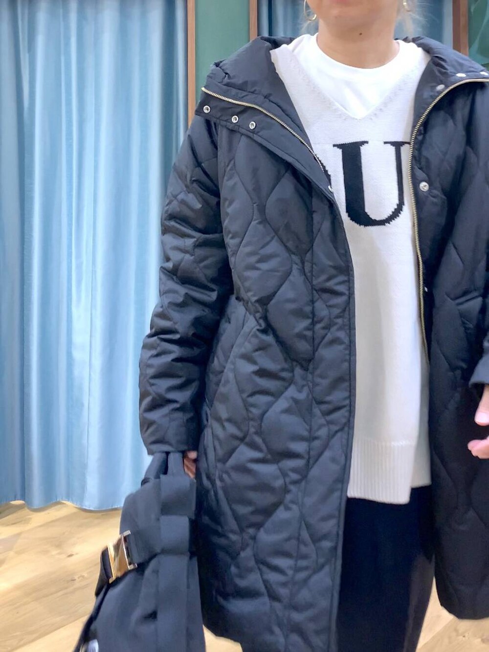 ベージュ系のニット/セーター、ブラック系のブルゾン、ブラック系のローファーを着用したレディースの秋コーディネートの5枚目の写真