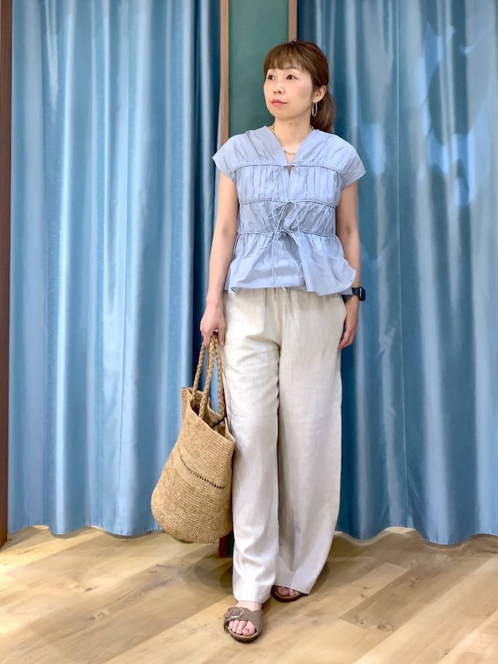 ホワイト系のタンクトップ、ベージュ系のその他パンツ、ブルー系のシャツ/ブラウスを着用したレディースの春コーディネートの2枚目の写真