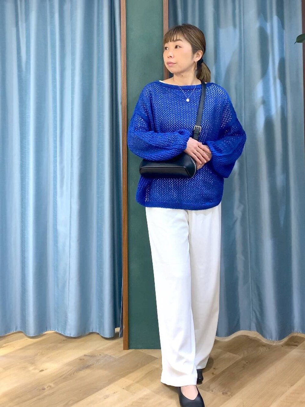 ホワイト系のスラックス、ブルー系のニット/セーター、ブラック系のパンプスを着用したレディースの冬コーディネートの4枚目の写真