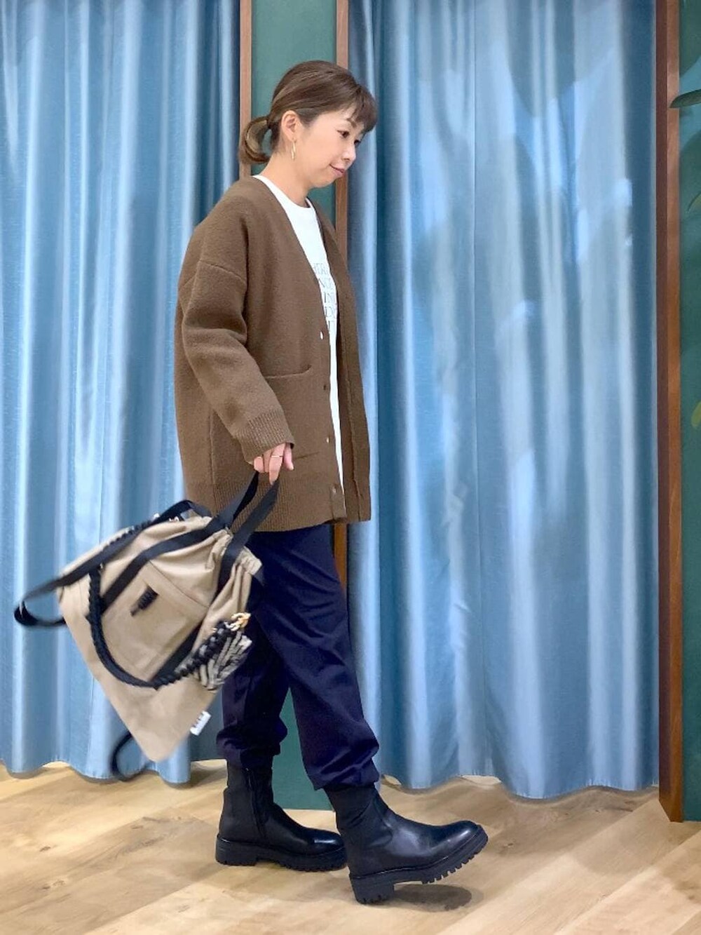 ブラック系のブーツ、ブルー系のその他パンツ、ブラウン系のバックパック/リュックを着用したレディースの冬コーディネートの2枚目の写真