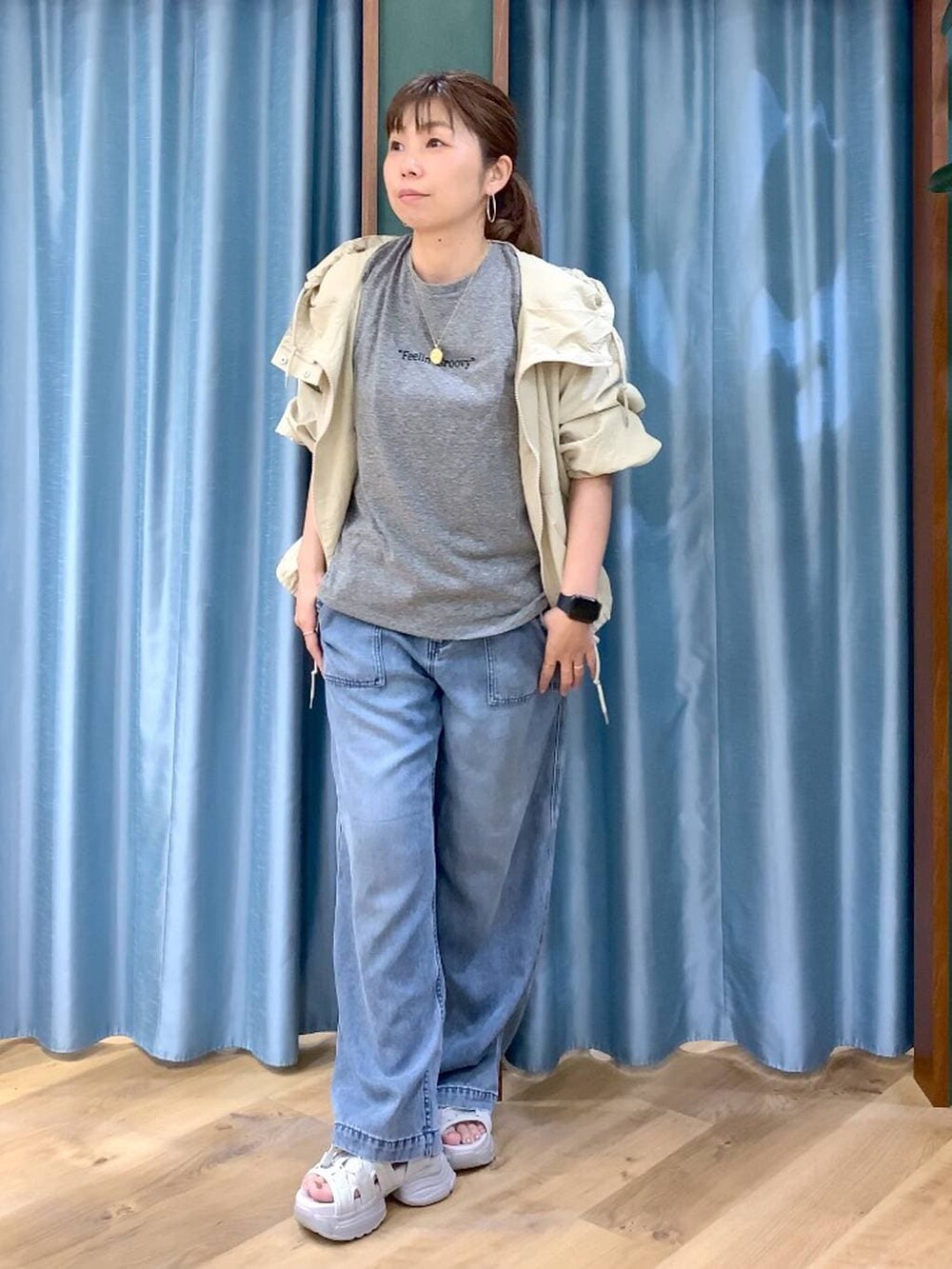 ブルー系のデニムパンツ、ベージュ系のブルゾン、グレー系のTシャツ/カットソーを着用したレディースの春コーディネートの2枚目の写真