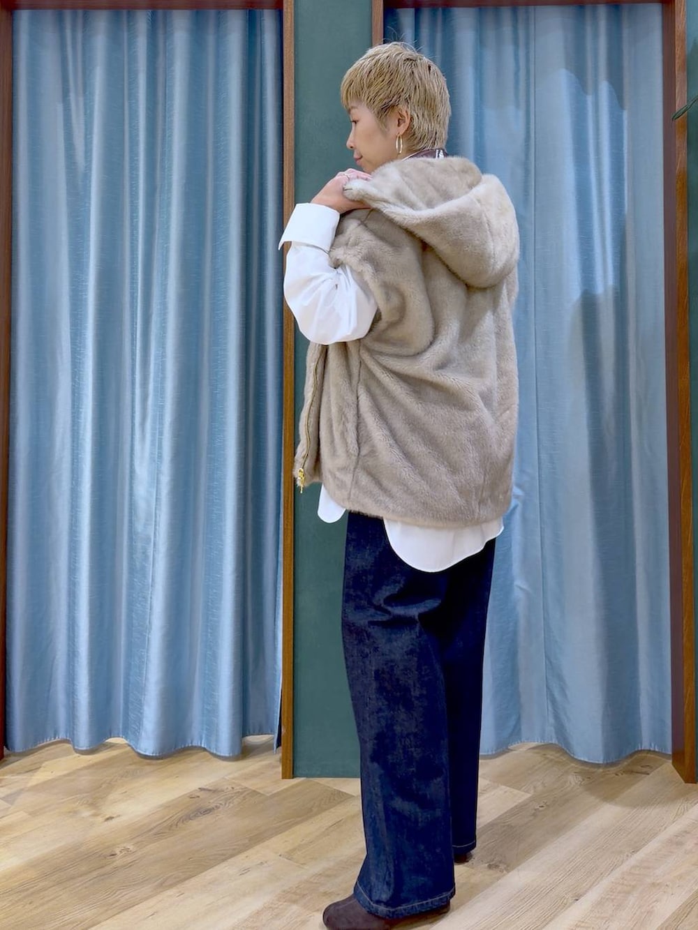 ブラウン系のブーツ、ブルー系のデニムパンツ、ホワイト系のシャツ/ブラウスを着用したレディースの秋コーディネートの4枚目の写真