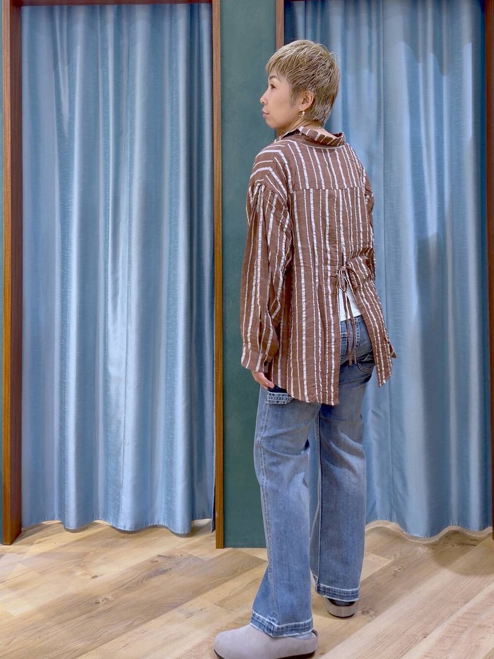ブラウン系のシャツ/ブラウス、ホワイト系のタンクトップ、ブルー系のデニムパンツを着用したレディースの秋コーディネートの7枚目の写真