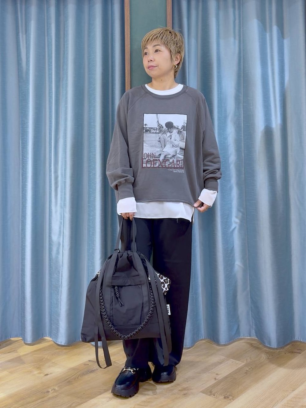 グレー系のスウェット、ブラック系のスニーカー、ホワイト系のTシャツ/カットソーを着用したレディースの秋コーディネートの2枚目の写真