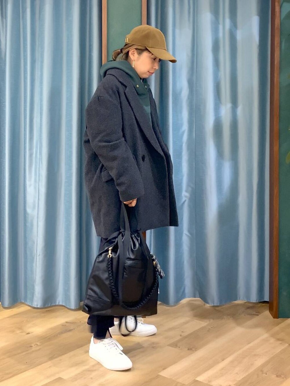 ブラック系のバックパック/リュック、ブルー系のシャツ/ブラウス、グリーン系のパーカーを着用したレディースの秋コーディネートの2枚目の写真