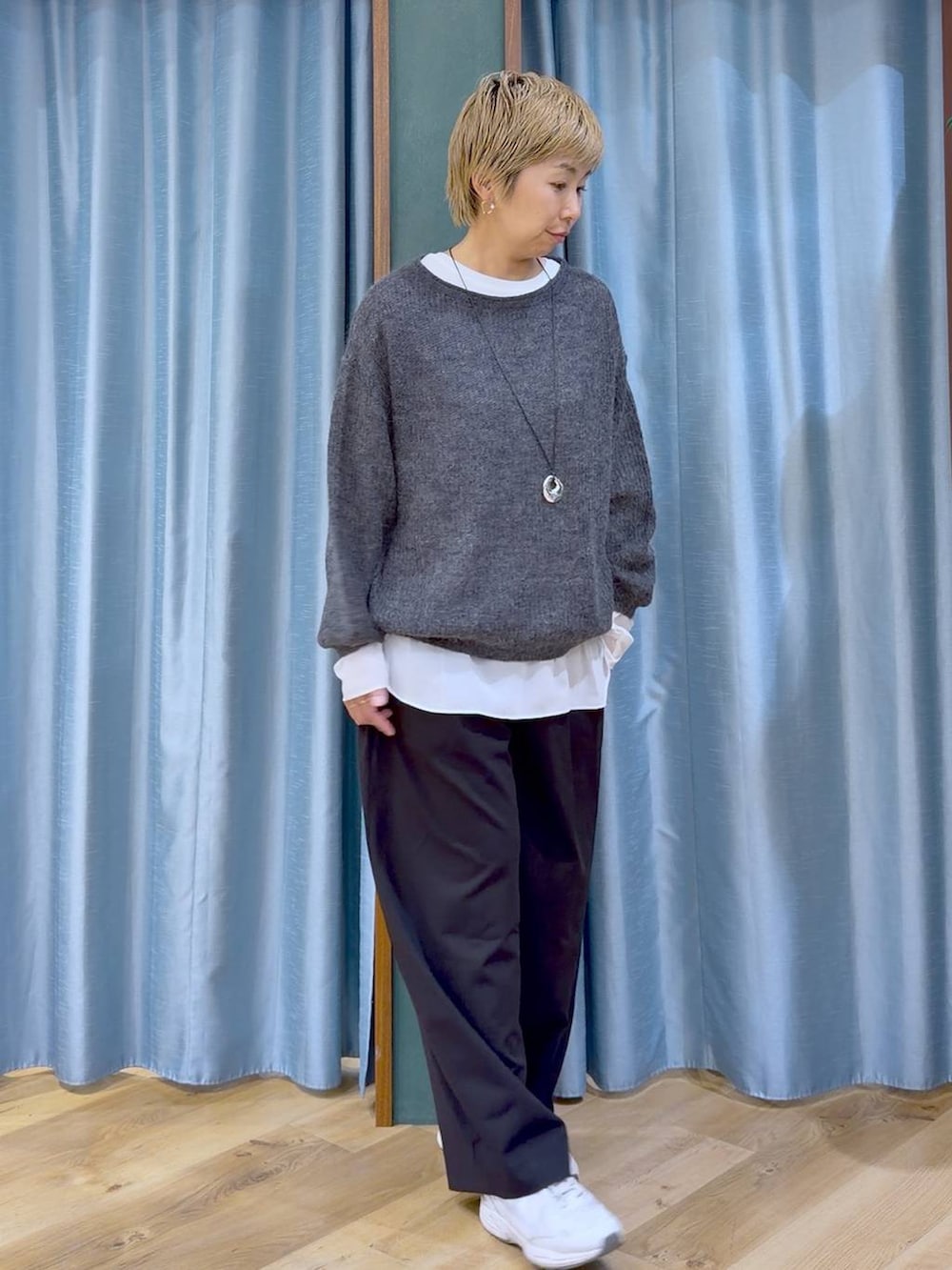 グレー系のニット/セーター、ブラック系のその他パンツ、ホワイト系のTシャツ/カットソーを着用したレディースの秋コーディネートの3枚目の写真